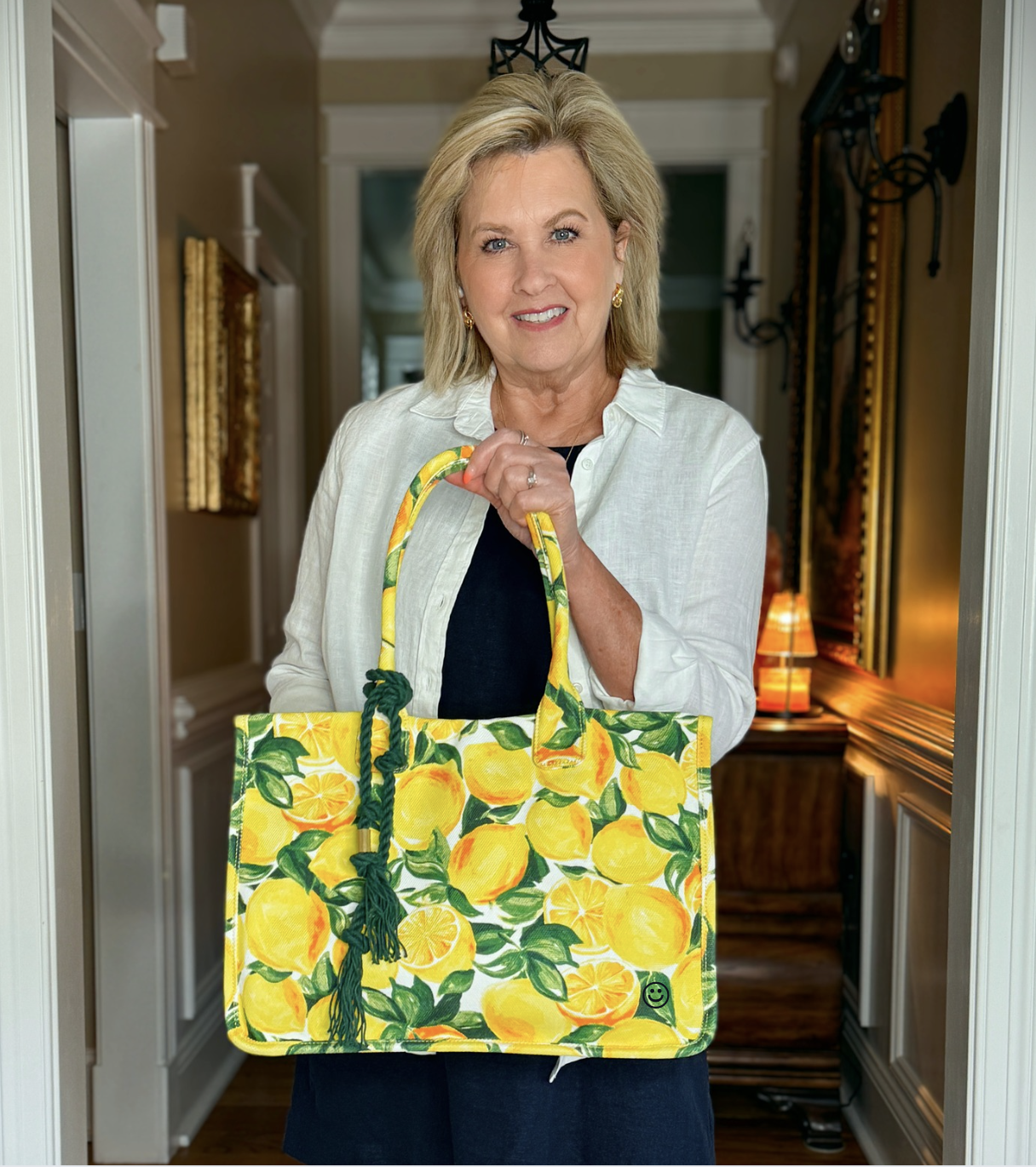 Tania wearing a navy dress with a white shirt and carrying a lemon handbag